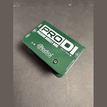 Zelená pasivní DI box s kovovým šasi. Na horní straně je bílý nápis PRODI a PASSIVE DIRECT BOX, vpravo dole text Made in Canada s ikonou javorového l…