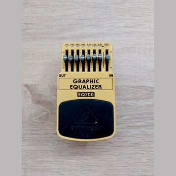 Žlutý kytarový pedál s nápisem GRAPHIC EQUALIZER a označením modelu EQ700. V horní části jsou posuvníky s popisy frekvencí 100, 200, 400, 800, 1.6k,…