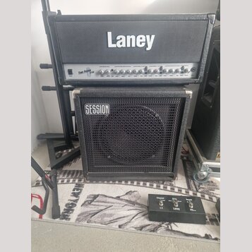 Kytarové kombo tvořené hlavou a kabinetem značky Laney. Na přední straně hlavy je nápis TUBE FUSION TF700 a na kabinetu je náleplka SESSION. Před zes…