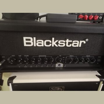 Černý kytarový kombozesilovač značky Blackstar. Na předním panelu jsou nápisy V-VOICE, GAIN, VOLUME, EQUALISATION, TVP, EFFECTS a MASTER, dále označe…