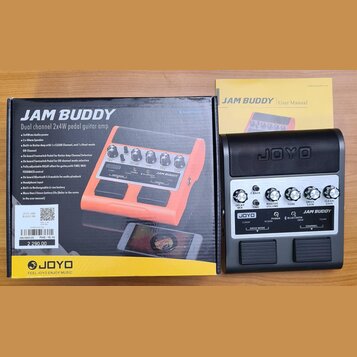 Fotografie zobrazuje černý kytarový pedálový zesilovač s nápisem JAM BUDDY a logem JOYO. Zařízení má pět ovládacích knoflíků s popisky F BACK, DELAY…
