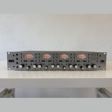 Stříbrný rackový mikrofonní předzesilovač s čtyřmi kanály. Na levé straně je nápis TONE-BLENDING 4-710d MIC PREAMPLIFIER a vpravo logo UA UNIVERSAL A…