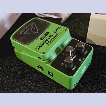Zelený kytarový efekt s černým ovládacím panelem a černým spínacím pedálem. Na horní části je nápis VINTAGE TUBE OVERDRIVE TO800 a na pedálu logo tec…