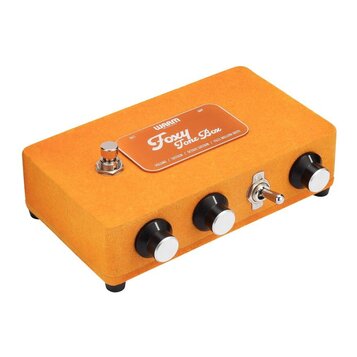 Kytarový efekt pedál v oranžovém textilním potahu. Na horní straně je kovový štítek s nápisy „WAARM“, „Foxy Tone Box“ a „VOLUME / SUSTAIN / OCTAVE SU…