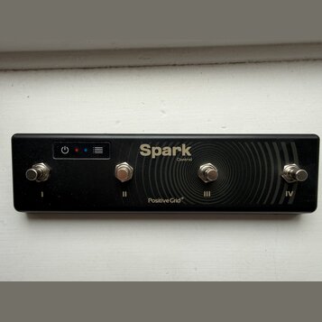 Černý ovladač s čtyřmi kovovými spínači, které jsou podepsány římskými číslicemi I, II, III a IV. Na horní části je nápis Spark Control a v dolní čás…