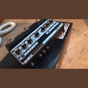 Černý efekt pedál s kovovým horním panelem. Na panelu je nápis Delay Machine DM-101 a logo BOSS. Jsou zde vidět ovládací knofíky, přepínače a konekto…