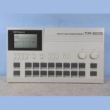 Bílý rytmický automat s displejem a ovládacími tlačítky. Na horní části je nápis RHYTHM COMPOSER TR-505 a v levém horním rohu logo Roland. Zařízení o…