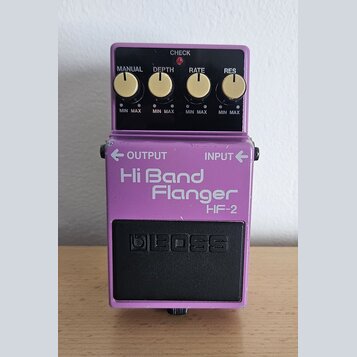 Fialový kytarový efekt s nápisem Hi Band Flanger HF-2 a logem BOSS na černém spínacím pedálu. Horní panel obsahuje čtyři zlaté otočné knoflíky s popi…