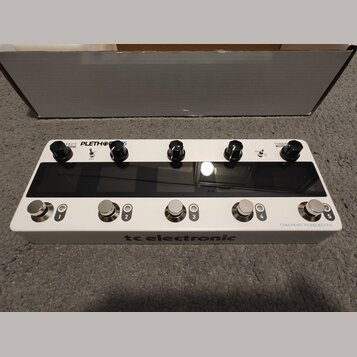Bílý kytarový efektový pedalboard značky tc electronic s nápisem TONEPRINT PEDALBOARD. Horní část obsahuje pět černých otočných knoflíků a dva přepín…