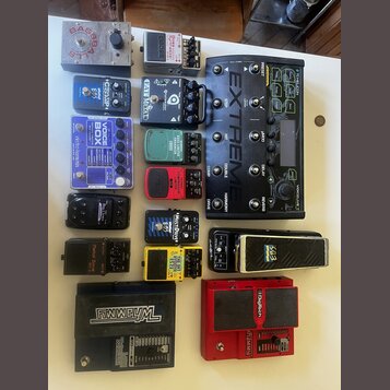 Sestava různých kytarových efektů a pedálů. Jsou zde zařízení s nápisy: „BASEBALLS“, „ DigiTech Whammy“, „Boss Metal Zone MT-2“, „BOSS TU-3“, „TC Ele…