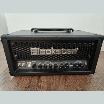 Černý kytarový kombo zesilovač s koženým potahem a kovovou mřížkou. Na mřížce je umístěno stříbrné logo Blackstar. Ovládací panel obsahuje přepínače…