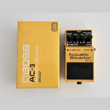 Žlutý efekt pedál Boss AC-3 Acoustic Simulator v originální žluté krabici. Na pedálu jsou čtyři ovládací knoflíky s nápisy REVERB LEVEL, BODY, TOP a…