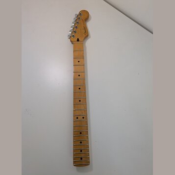 Světle hnědý javorový krk elektrické kytary s prázdnými otvory pro pražce. Na hlavě je viditelné logo Fender a nápis MADE IN USA. Krk je vybaven chro…