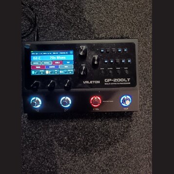 Černý kytarový procesor s displejem a ovládacími prvky. Na přístroji je bílý nápis VALETON GP-200LT MULTI-EFFECTS PROCESSOR. Displej zobrazuje text 0…