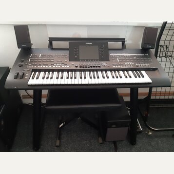 Černý digitální klavír s bílými a černými klávesami na černém stojanu. Na horním panelu je displej a nápisy YAMAHA a MONTAGE8. Součástí sestavy jsou…