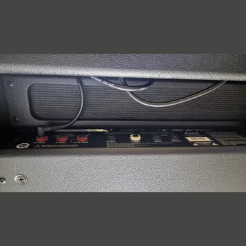 Zadávací panel zesilovače značky Marshall s černým povrchem. Jsou zde viditelné výstupní konektory pro reproduktory s nápisy 16 OHM, 8 OHM a 2x16 OHM…