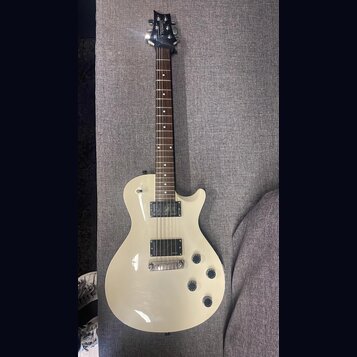 Krémová elektrická kytara s tmavým hnedým hmatníkem. Na hlavě je bílý nápis "ALBERTO". Tělo má dva humbuckery, čtyři otočné knofíky a chromovaný most…