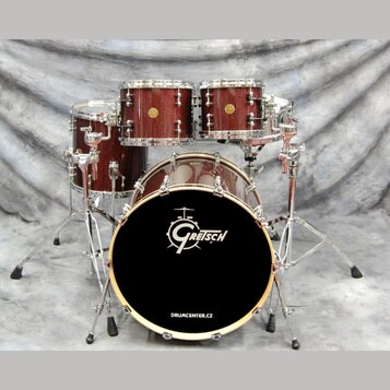 Bubnová sada v tmavě hnědé barvě s texturou dřeva a chromovaným kováním. Na přední bláně basového bubnu je bílé logo Gretsch a nápis DRUMCENTER.CZ. S…