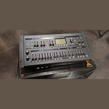 Černý polyfonní syntetizátor s nápisem DeepMind 12 ANALOG 12-VOICE POLYPHONIC SYNTHESIZER. Na předním panelu jsou vidět knofíky, tlačítka a displej s…