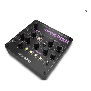 Černý string syntetizér s nápisem streichfett STRING SYNTHESIZER a logem waldorf na boku. Zařízení má několik černých otočných ovladačů, čtyři žlutá…