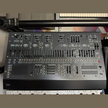Černý analogový syntetizátor s nápisem ARP v levém dolním rohu a označením MODEL 2600 SYNTHESIZER v pravé dolní části. Přední panel obsahuje množství…