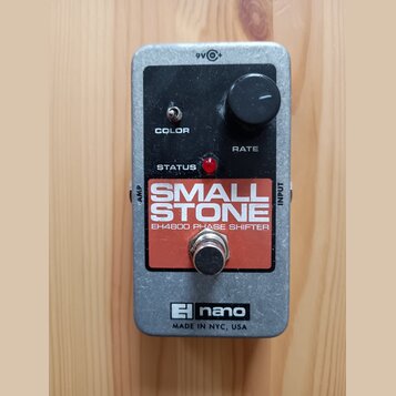 Kytarový efekt v kovovém šedém šasi s černým horním panelem. Na panelu je nápis SMALL STONE a pod ním EH4800 PHASE SHIFTER, ovládací knoflík RATE, př…