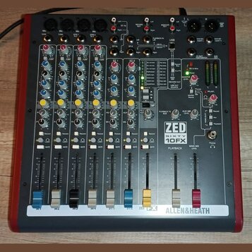Míchací pult s červeným šasi a šedým ovládacím panelem. Na pravé straně je vidět logo ZED SIXTY 10FX a v dolní části nápis ALLEN&HEATH. Přístroj obsa…
