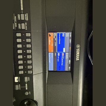 Detailní záběr na ovládací panel a displej klavíru značky YAMAHA. Na modrém displeji jsou viditelné nápisy ConcertGrand, CoolBBeat, VP Soft a StudioS…