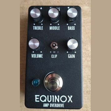 Černý kytarový efekt s nápisem EQUINOX AMP OVERDRIVE. Na horní straně jsou tři ovládací knoflíky s popisky TREBLE, MIDDLE a BASS. Ve střední části se…