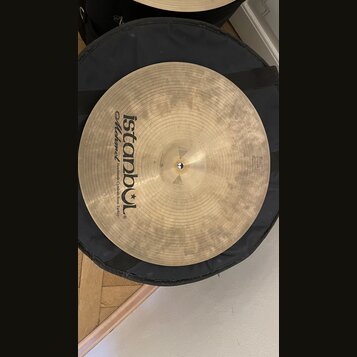 Kruhová činely z mosazi v přirozené zlatavé barvě s viditelným broušením. Na povrchu je černý nápis „istanbul Mehmet Handmade Cymbals from Turkey“. V…
