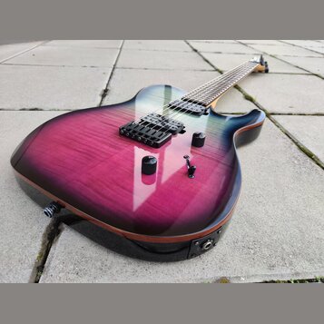 Elektrická kytara s tělem v purpurovo-černém gradientu a viditelnou strukturou dřeva. Nástroj má dva humbuckery, tři černé ovládací knofíky a jeden p…