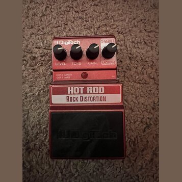 Červený kytarový efekt s černým pedalem. Na přístroji jsou nápisy HOT ROD ROCK DISTORTION a logo DigiTech. Obsahuje čtyři ovládací knoflíky s popisky…