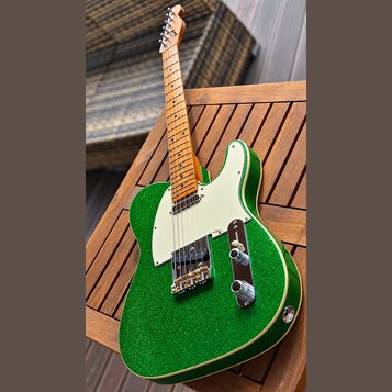 Zelená elektrická kytara typu Telecaster s třpytivým povrchem a bílým pickguardem. Má javorový hmatník a dvě snímače, z nichte jeden je humbucker. Na…