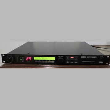 Černý rackový efektový procesor s nápisem YAMAHA SPX990. Na displeji svítí červené číslo 29 a zelený text REVERSE GATE Reverse U15 P06 P03 P04. Zaříz…