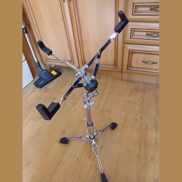 Kromě hudebního nástroje není na fotce vidět žádný konkrétní instrument, pouze chromovaný stojan s černými gumovými koncovkami. Stojan má tříramennou…