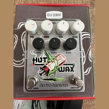 Kytarový efekt pedál s kovovým stříbrným povrchem a nápisem electro-harmonix. Na spodní části je velký grafický motiv s nápisem HOT WAX a dvěma spína…