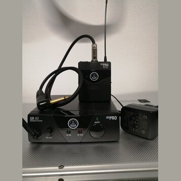 Černý bezdrátový mikrofonní systém značky AKG. Na přijímači je nápis SR 40 STATIONARY RECEIVER a MINI PRO, na vysílači MINI PRO PT 40. Soubor obsahuj…