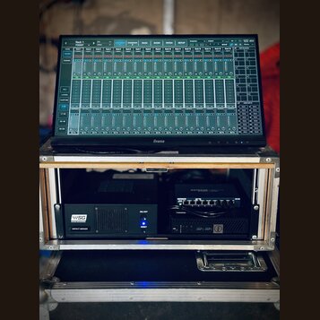 Na fotce je vidět monitor značky Iiyama, na kterém je zobrazeno rozhraní pro ovládání zvukového mixu s názvem Rack 1. Monitor je umístěn na hliníkové…