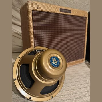 Na fotografii je kytarový zesilovač v béžovém potahu s hnědou mřížkou a zlatý reproduktor. Na horní hraně zesilovače je nápis Fender Harvard. Reprodu…