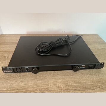 Černý rackový kondicionér napájení s nápisem FURMAN na levé straně a označením PL-8C E vpravo. Na předním panelu se nachází vstup pro napájecí kabel,…