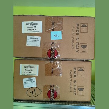 Dvě hnědé kartonové krabice s nápisy MADE IN ITALY a RoHS Compliant. Na krabicích jsou bílé nálepky s textem B&C SPEAKERS, Recone Kit 12TBX100-4 a žl…
