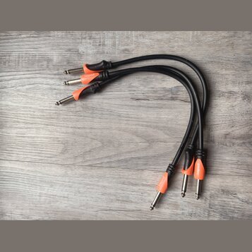 Tři černé audio kabely s oranžovými plastovými krytkami konektorů. Na každé oranžové krytce je bílý nápis bespece. Kabely jsou v dobrém stavu a leží…