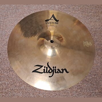 Kruhové činely v bronzové barvě s viditelným broušením povrchu. Na horní části je logo A a nápis CUSTOM HIHAT BOTTOM 14"/36 cm. Ve spodní části je ve…