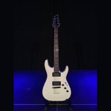 Bílá elektrická kytara s dvojstupňovitým tělem a tmavým hmatníkem. Nástroj má dva humbuckery, jeden ovládací knoflík hlasitosti a jeden tón. Na hlavě…
