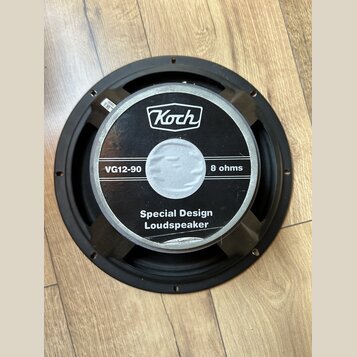 Kruhové reproduktorové jednotky s černým rámem. Na středovém štítku je bílé logo Koch a nápisy VG12-90, 8 ohms a Special Design Loudspeaker. Povrch š…