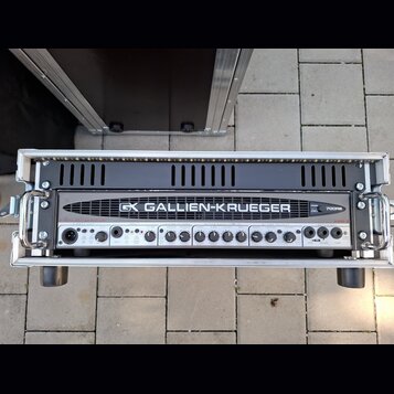 Černý basový zesilovač v hliníkovém transportním kufru. Na předním panelu je nápis GALLIEN-KRUEGER a logo GK, dále označení modelu 700RB. Zařízení ob…