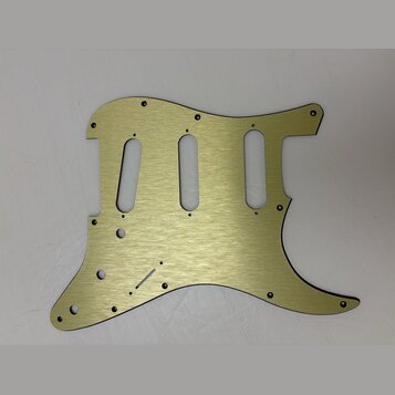 Zlatý kovový pickguard pro elektrickou kytaru s broušeným povrchem. Má tři oválné výřezy pro snímače a několik malých otvorů na šrouby. Na povrchu ne…