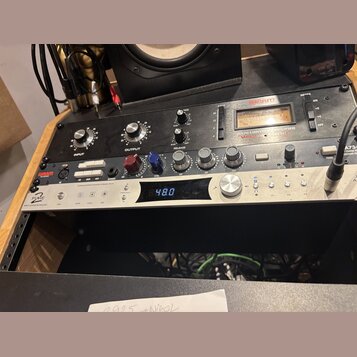 Na fotografii jsou dvě rackové jednotky v černém a stříbrném provedení. Horní černý přístroj nese nápisy WARM AUDIO a LA76 LIMITING AMPLIFIER s někol…