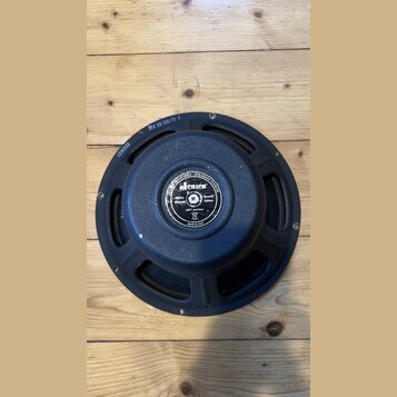 Zadní strana černého reproduktoru s kovovým rámem. Uprostřed magnetu je štítek s nápisy: JENSEN INDUSTRIES - SPEAKERS DIVISION, Jensen, Alnico Magnet…