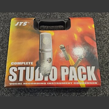 Kartonová krabice s černou plastovou rukojetí. Na povrchu je nápis JTS® a velký text COMPLETE STUDIO PACK, pod kterým je uveden popis VOCAL RECORDING…
